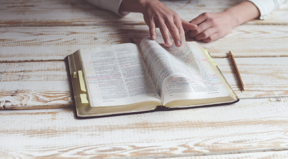 Female reader turning the pages of the Bible